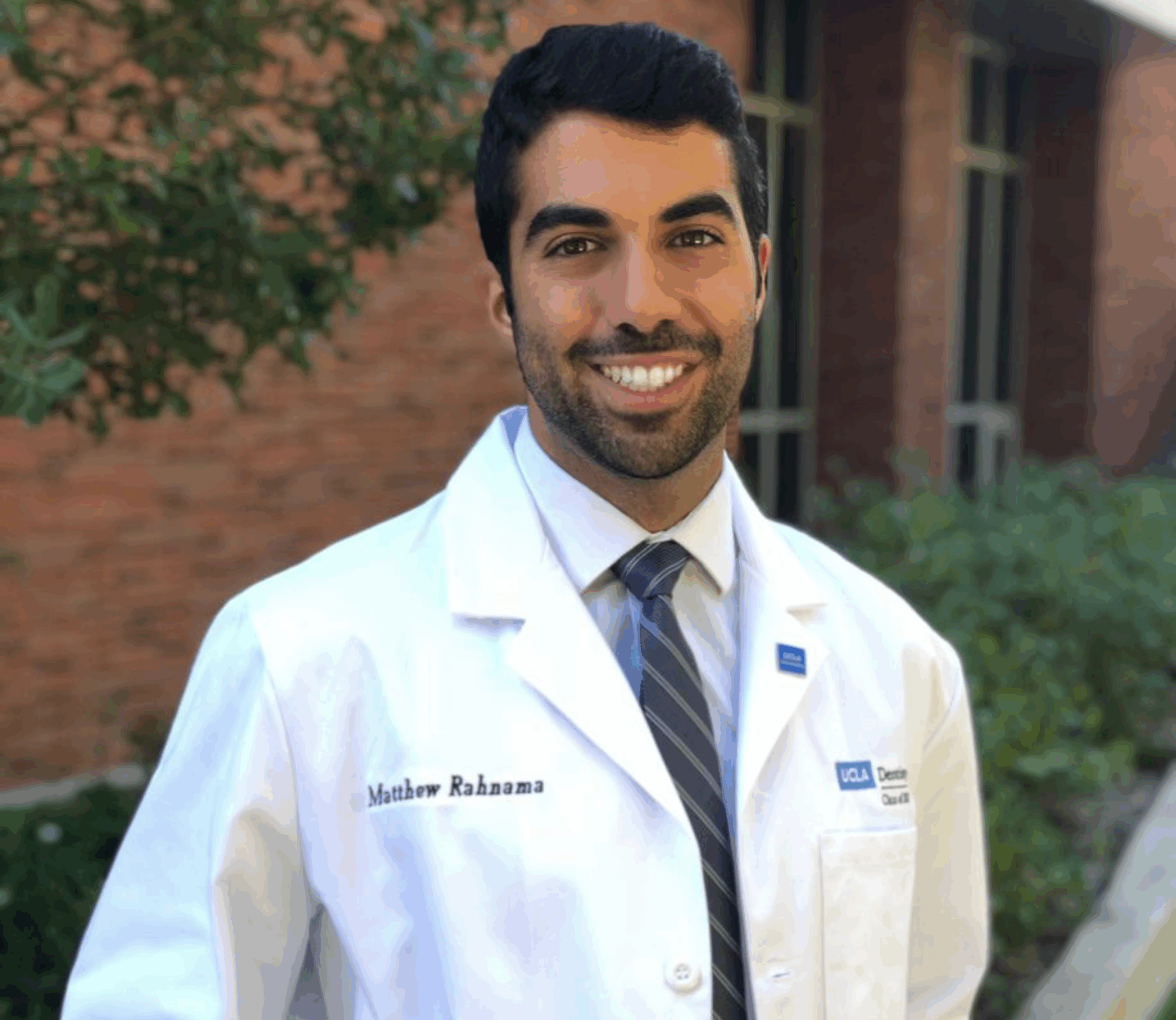 Doctor smiling in white coat outdoors